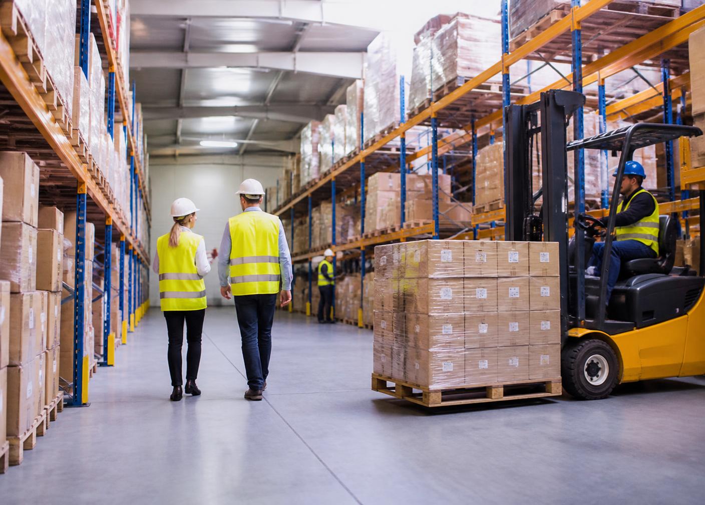 Warehouse team coordinating palletised cargo with a forklift